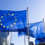 Europäische Flaggen als Symbol für die verbindlichen CRA-Fristen 2026 und 2027