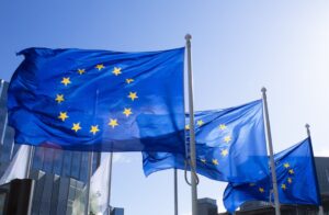 Europäische Flaggen als Symbol für die verbindlichen CRA-Fristen 2026 und 2027