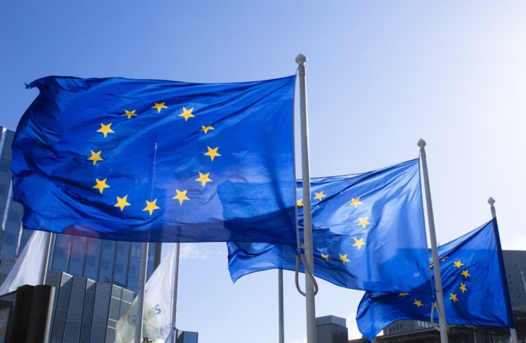 Europäische Flaggen als Symbol für die verbindlichen CRA-Fristen 2026 und 2027